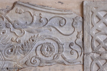 Sculpted Stone Tablet Detail with a Flower at the Santa Maria in Trastevere Church Portico in Rome, Italy