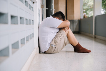 Thai student bullying victim by classmates crying sadly being bullied, concept of being bullied by schoolmates causing stress and physical and psychological harm..