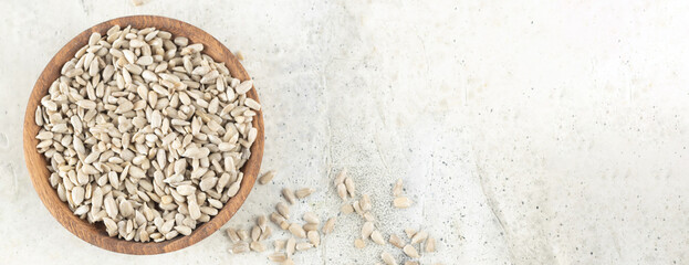 Banner. Sunflower seeds lie in a bowl on a light background