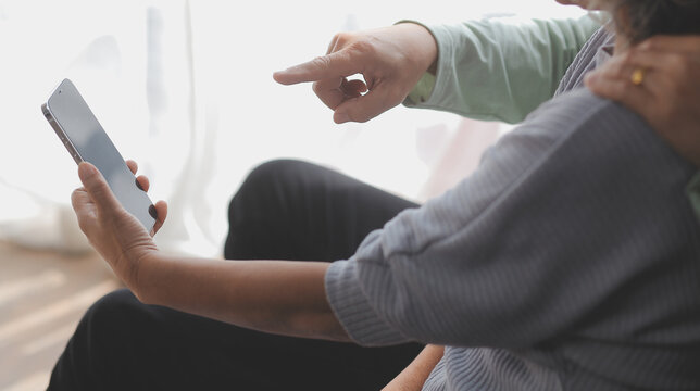 Asian mature senior couple look talk to smartphone camera at home. video calling communicate in online chat