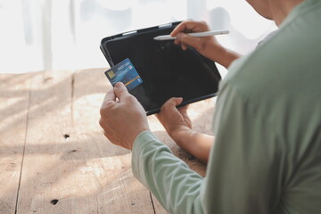 Close up mature man holding plastic credit card, senior couple family paying online, using laptop, satisfied older customers making secure internet payment, shopping, browsing banking service