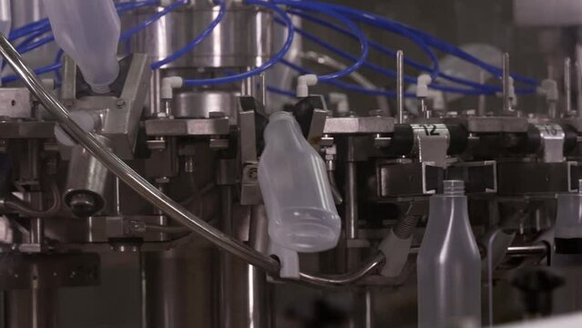 Sauce production line. Semi-transparent plastic bottles moving through the production line. Automatic line for processing of sauce. 