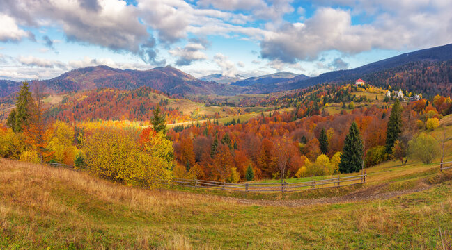 carpathian countryside at sunrise in autumn. rural fields and forested hill in morning light. distant ridge beneath a sky with clouds