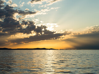 Cloudy sky during sunset with reflection in the Adriatic sea, in Zadar, Croatia