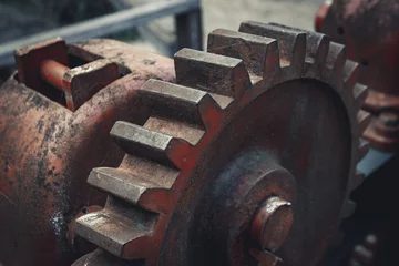 Fotobehang Close-up of Durable Metallic Machinery in Construction. Metalwork equipment in close-up view, featuring alloy iron. Mechanical red cogwheel in an industrial machine. © Emvats