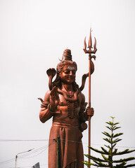 The giant Shiva statue of Durga at the Hindu temple Ganga Talao, Grand Bassin, Mauritius. close-up shot with blue sky. 