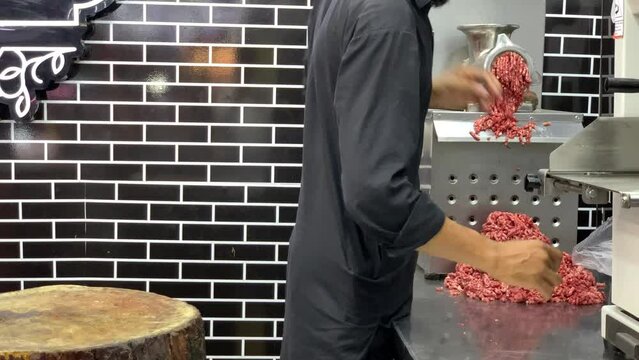 Mince is falling out of the meat grinder. Minced meat in a butcher shop, Mince is being made in an electric grinder in a meat shop.