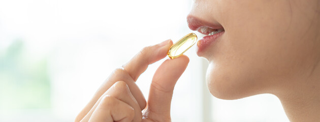 Nourishing the Body, Embracing Wellness: A Person Taking Fish Oil Supplements for Optimal Health...