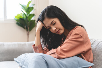 Stressed female feeling depressed and lonely on the sofa in the house.