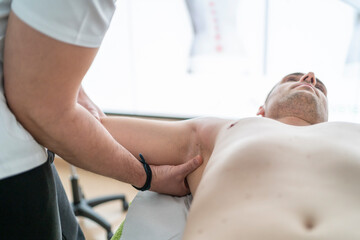 Unrecognizable professional therapist treating patient during massage session