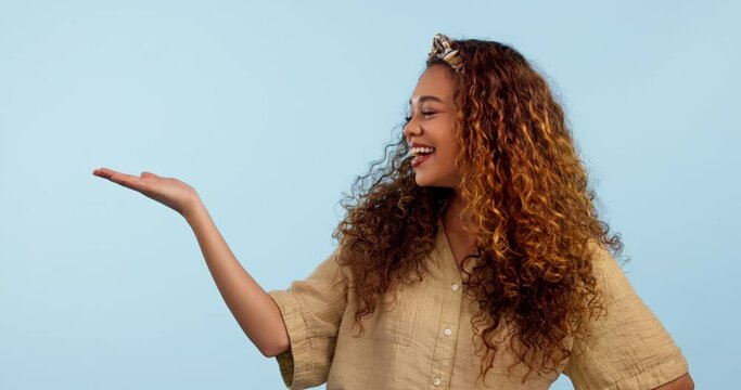 Happy, face and woman with hand holding space in studio for deal, announcement or promo on blue background. Smile, portrait and lady model show sale, service or giveaway, info or platform offer