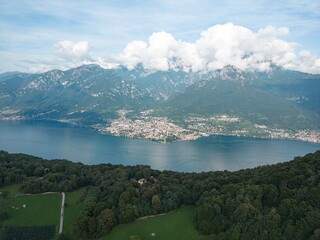 Lake Como's beauty captured aerially near Lecco. Mountains and gentle clouds complement the tranquil scene