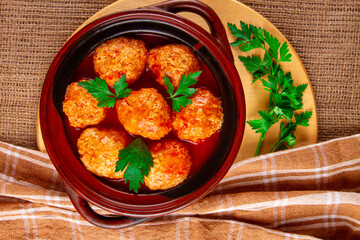 Sicilian-style meatballs in tomato sauce decorated with parsley leaves