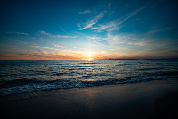 Italian sunset on the beach in landscape, Capri and Ischia in background - obrazy, fototapety, plakaty