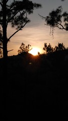 Sunset hiding in the forest mountain