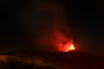 Panoramica sull'Etna durante una grande eruzione di notte con grande emissione di fumo e lava incandescente - Sicilia