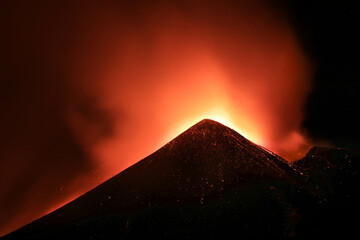 Cratere Etna in eruzione in primo piano durante suggestiva notte con lava incandescente ed emissione di cenere e fumo