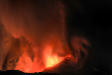 Etna panoramica suggestiva di notte sul vulcano in eruzione con lava tra cenere gas e vapore nel cielo notturno dal cratere del 13 Agosto 2023	