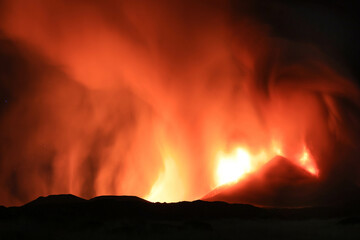 Etna panoramica in eruzione di notte tra cenere gas e vapore nel cielo notturno dal cratere della cima del vulcano del 13 Agosto 2023