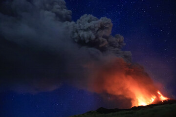 Etna durante suggestiva eruzione di notte con grandi emissioni di cenere nel cielo notturno dal cratere della cima del vulcano del 13 Agosto 2023