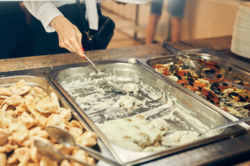 The teenager puts food on his plate. A steel tray with food in the school's self-service buffet....