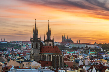 Fototapeta premium Prague cityscape of Church of Our Lady before Tyn and Prague castle in an orange twilight.