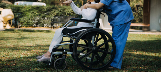 Asian young woman nurse at nursing home take care disabled senior man. Caregiver doctor serve physical therapy for older elderly patient to exercise and practice walking on walker or cane at backyard.