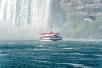 Fototapeta premium Tour boat sailing towards huge water flows down the waterfall, Horseshoe Water Fall in Niagara