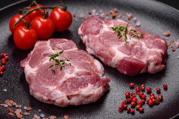 Fresh juicy pork steaks with salt, spices and herbs