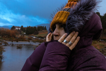 Native woman covering her ears from the wind that runs in extreme cold climates.