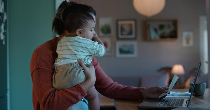 Laptop, remote work or multitask with a mother and baby in their home in the evening for overtime. Computer, family and business woman working in the kitchen with her infant child as a single parent