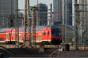 red train driving to the station with the skyscrapers in the background