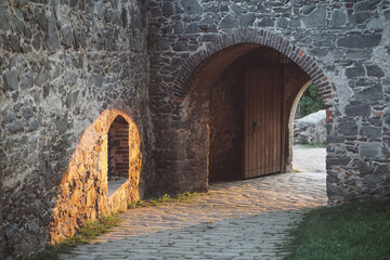 Gate to the historical middle age castle with sunset in the background - stony archway of Kuneticka mountain (Pardubice)