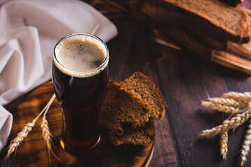 A glass of cold kvass and rye bread for fermentation on the table - obrazy, fototapety, plakaty