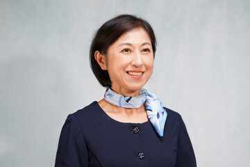 首にスカーフを巻いた笑顔の中年女性 スカーフの使い方