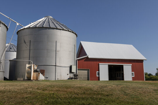 Grain Bins On A Farm In The Midwest US. Grain Bins Can Be Used To Store Wheat, Corn, Oats, Seeds, Soybeans, Sunflower Seeds And Barley.