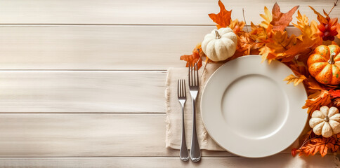 Thanksgiving fall place setting with cutlery and fall leaf arrangement, top view, flat lay. Autumn place setting with fall leaves, napkin and pumpkins. - obrazy, fototapety, plakaty