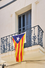 Catalan independence flag hanging from a window demanding the independence of Catalonia - obrazy, fototapety, plakaty
