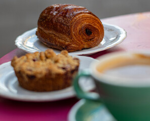 Inviting Morning Delights: Sunlit Terrace Breakfast with Creamy Coffee, Blueberry Tart, and Chocolate Croissant