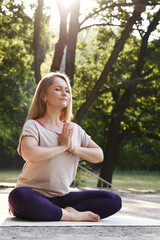 Woman in yoga position meditate with gratitude and relax outdoors in park. Concentration and body...