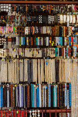 Different wristbands and necklaces for sale on a street fair