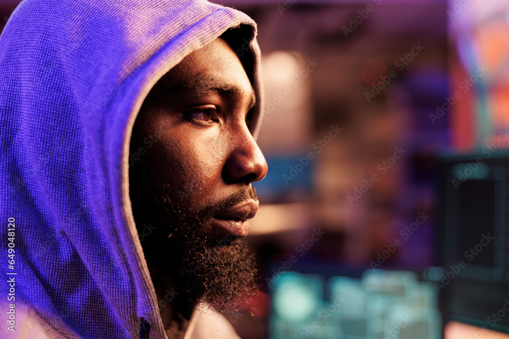 Poster african american hacker in hood breaking into computer network system and hacking server. young man 