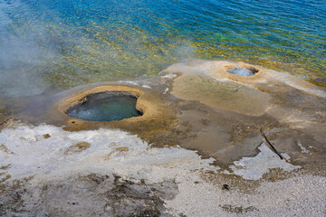 Cauldron geysers at West Thumb Basin Yellowstone National Park, Wyoming, USA. Steaming hot pools sit in Yellowstone Lake.
