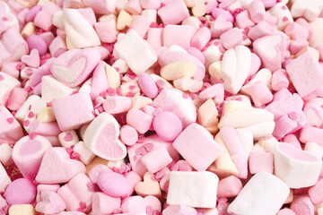 Confectionery and sweeties background: light pink and white marshmallows, sugar confetti, bonbon and candies
