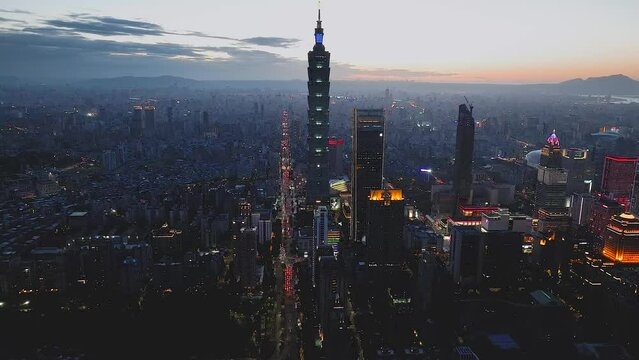 台北の台北101などの高層ビル群と街並みの夜景と夕日　台湾　空撮