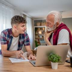 student caucasian male teenager and his grandfather or professor study