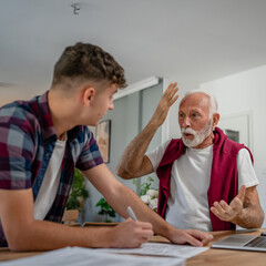student caucasian male teenager and his grandfather or professor study
