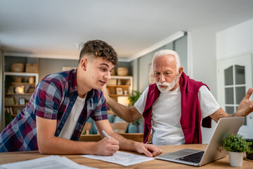 student caucasian male teenager and his grandfather or professor study - obrazy, fototapety, plakaty