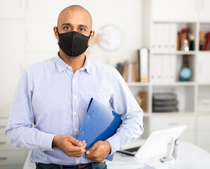 Viral threat, seasonal viral diseases. Man works in the office in a medical mask, protecting office workers from viruses