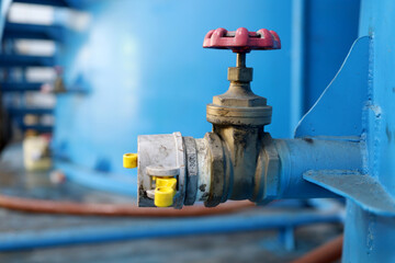 The brass gate valve is installed in the storage tank. oil and water industry equipment. - obrazy, fototapety, plakaty